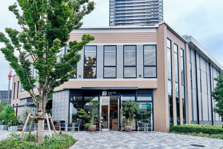 SiKiTO CAFE幕張店の外観。ガラス張りの入口と店頭の植木、テラス席が見える