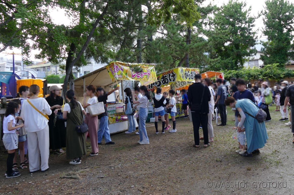 胡録神社の境内に並ぶ露店と参拝客の様子