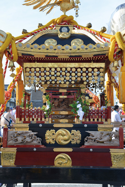 鳳凰を頂いた金色の神輿が千倉漁港の広場に据えられ、担ぎ手が周囲に集まる様子