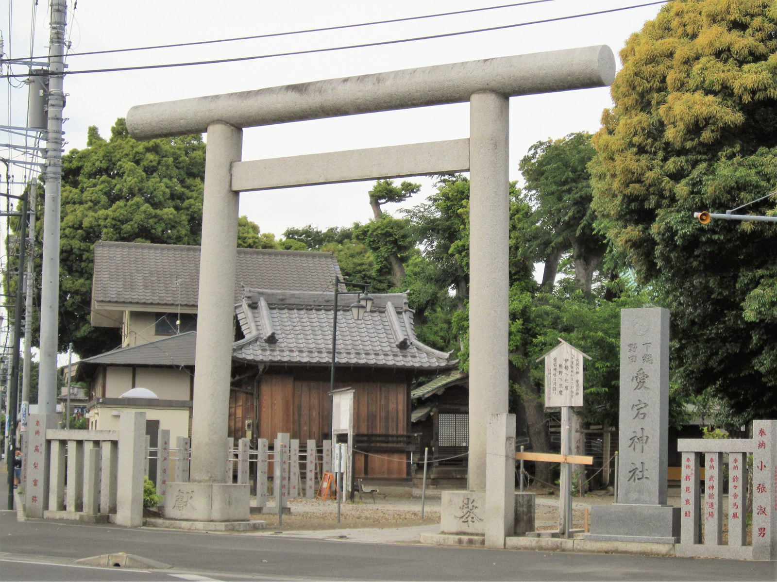 野田市の愛宕神社。石鳥居の奥に瓦屋根の社殿が立ち、右手に「愛宕神社」の社号標