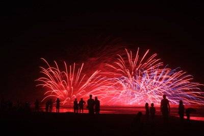海辺の夜空に大きく開くスターマインの花火