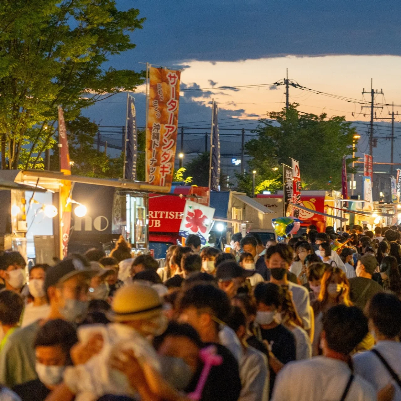 夕暮れの柏の葉T-SITE夏祭りで、縁日の屋台が並ぶ通りを大勢の来場者が歩く様子