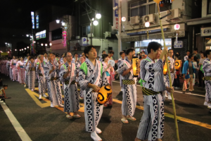 揃いの半纏を着た人々が本町通りを踊り歩く、夜のおどりパレードの様子