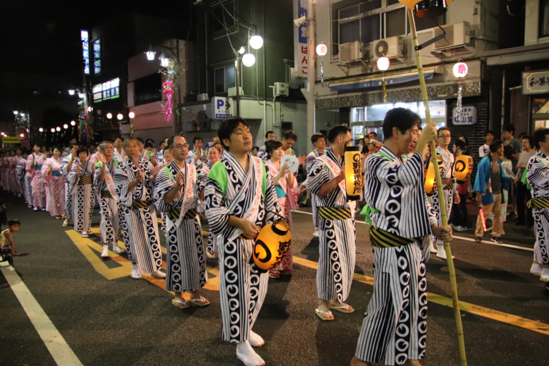 揃いの半纏を着た人々が本町通りを踊り歩く、夜のおどりパレードの様子