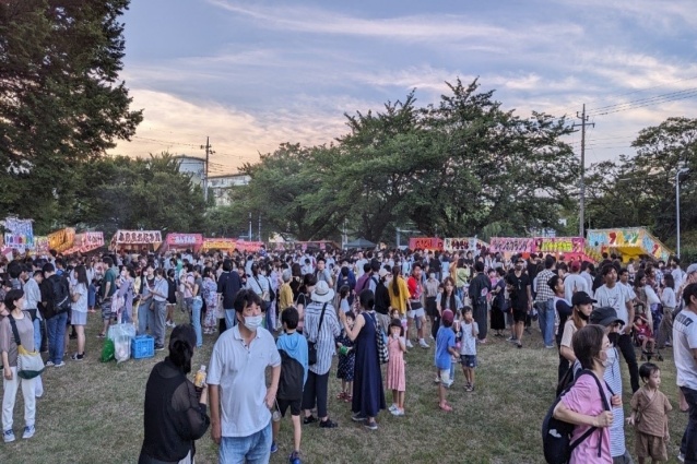夕暮れの花見川団地まつりで屋台に集まる来場者