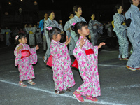 ピンクや赤の浴衣を着て盆踊りに参加する子どもたち