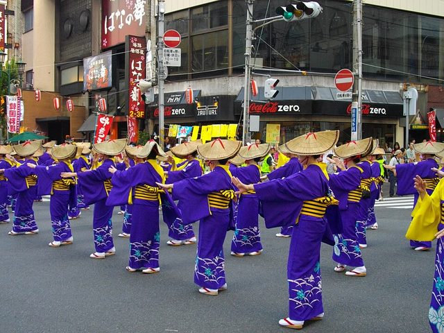 柏の市街地で列をつくって柏おどりを踊る、編み笠と紫の浴衣の踊り手