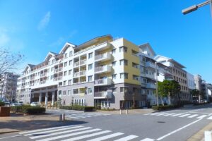 幕張ベイタウンの低層マンションが沿道に連なる街並み。電柱のない広い車道と街路樹が続く