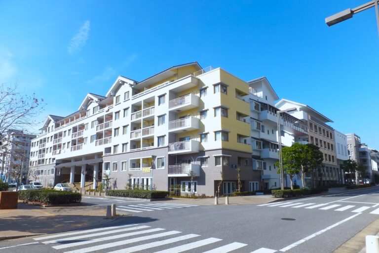 幕張ベイタウンの低層マンションが沿道に連なる街並み。電柱のない広い車道と街路樹が続く