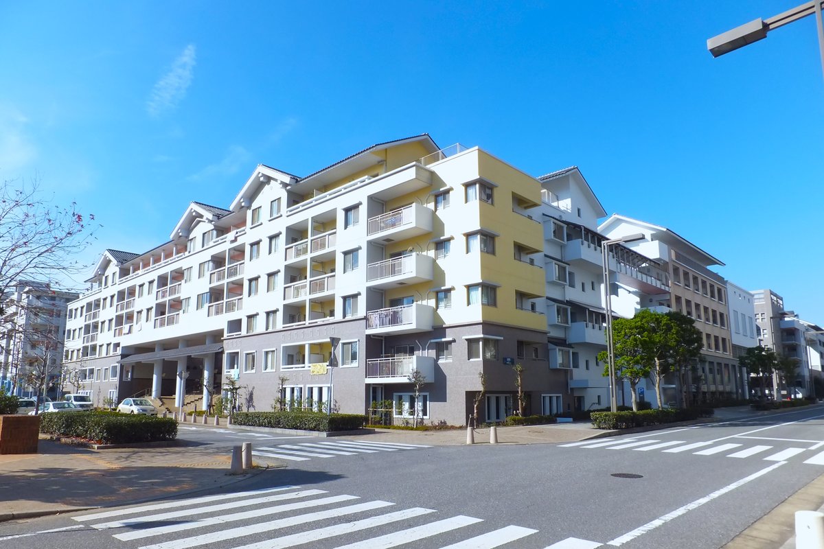 幕張ベイタウンの低層マンションが沿道に連なる街並み。電柱のない広い車道と街路樹が続く