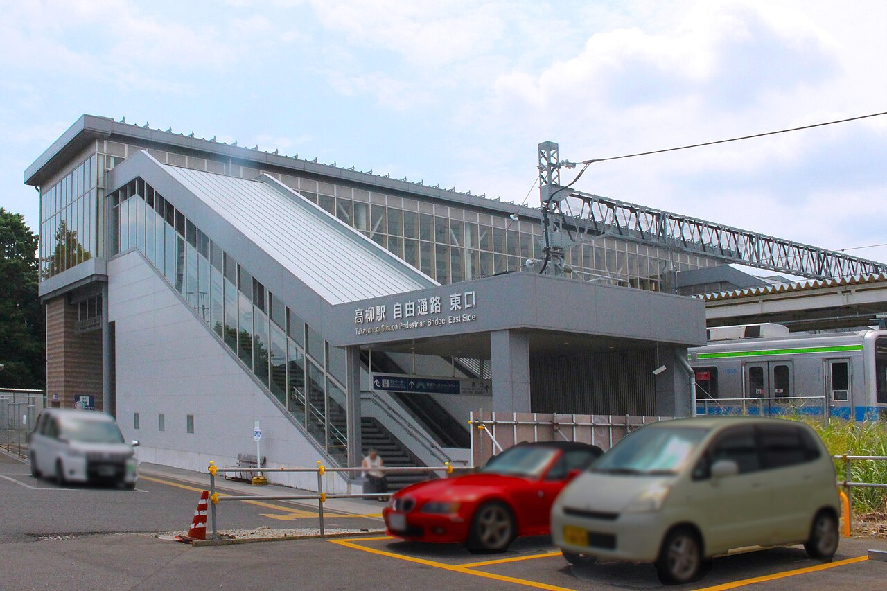 東武アーバンパークライン 高柳駅の東口。高架のガラス張り階段室と停車中の車両