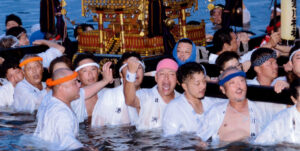 御浜下りで神輿を担いで海に入る白装束の担ぎ手たち
