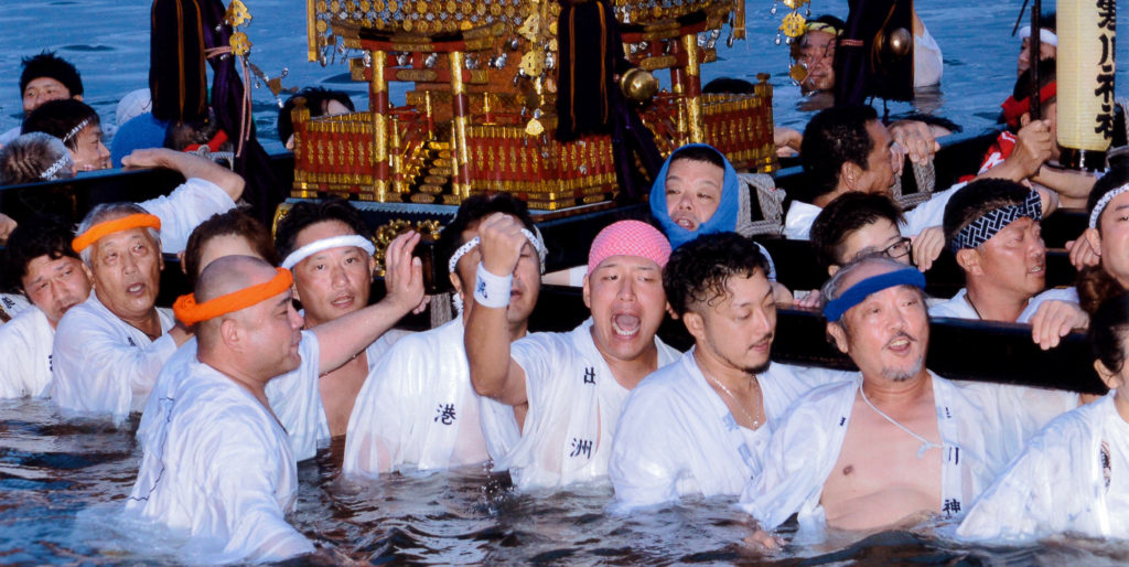 御浜下りで神輿を担いで海に入る白装束の担ぎ手たち