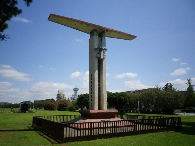 稲岸公園に立つ民間航空発祥之地の記念塔。翼の形をした白いモニュメントと芝生広場