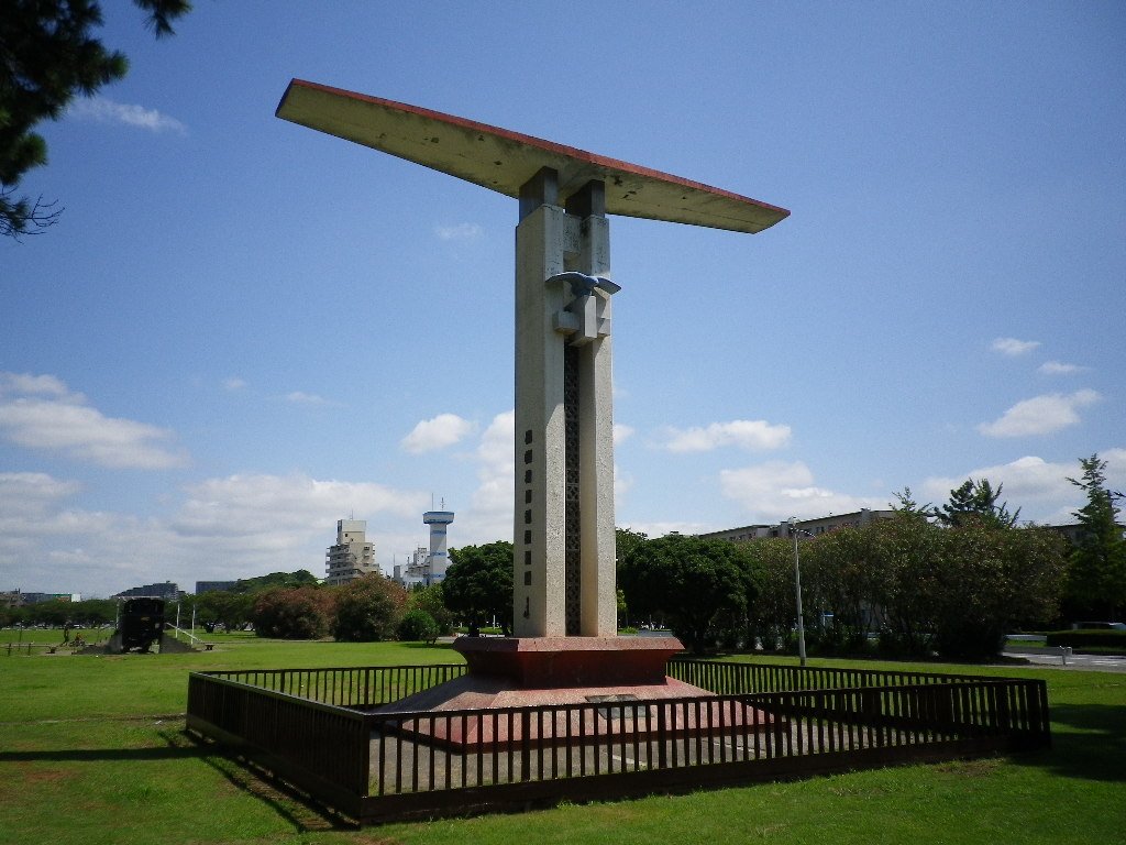 稲岸公園に立つ民間航空発祥之地の記念塔。翼の形をした白いモニュメントと芝生広場