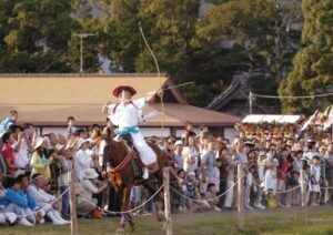 弓を引き絞り馬場を駆ける吉保八幡神社の流鏑馬の射手