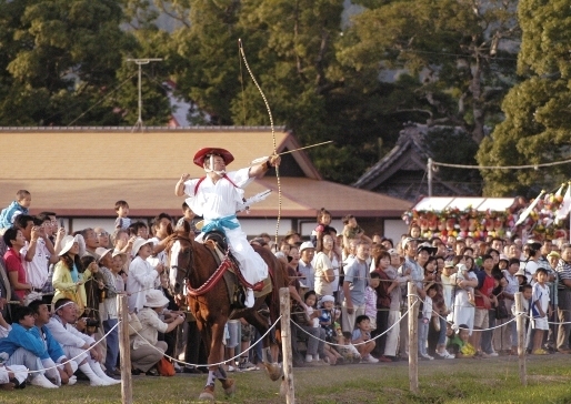 弓を引き絞り馬場を駆ける吉保八幡神社の流鏑馬の射手