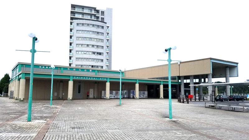 京成ちはら台駅の駅舎外観。駅前広場とバス乗り場、奥に高層マンションが見える