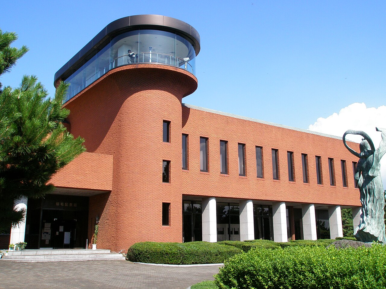 赤レンガ張りの稲毛記念館の外観。円筒形の塔の上に総ガラス張りの展望室が載っている