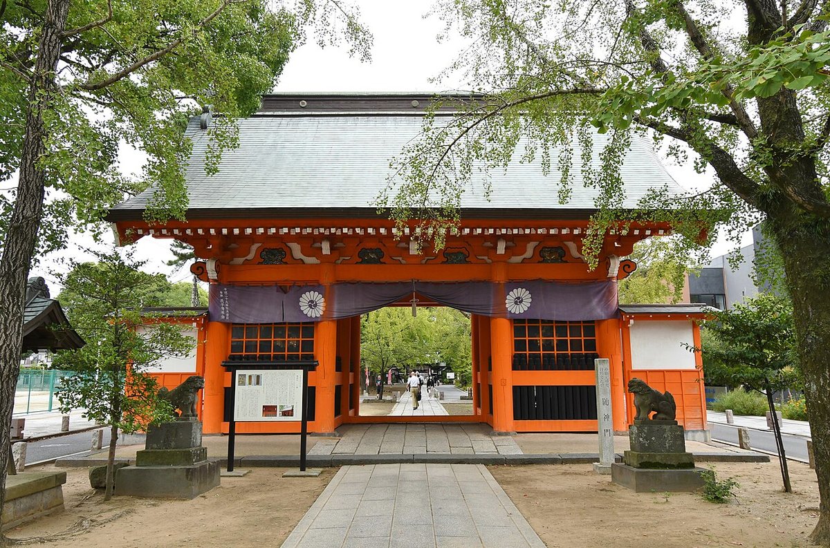 葛飾八幡宮の朱塗りの随神門を正面から見た写真。紫の幕に白い菊紋、左右に狛犬