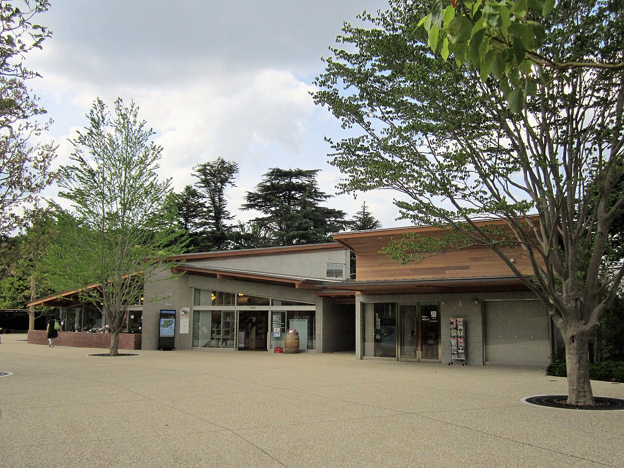 清水公園の入口にある平屋の建物。木の庇が大きく張り出し、ガラス張りの売店とインフォメーションが並ぶ。手前は広い舗装広場で、ゲートや料金所は見当たらない