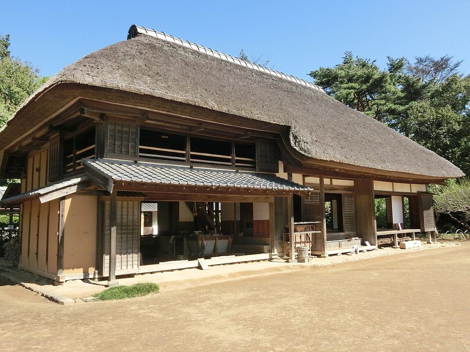 房総のむらの上総の農家。茅葺き屋根の大きな2階建ての民家で、軒下の縁側と土間の入口が開け放たれ、前は土の庭になっている