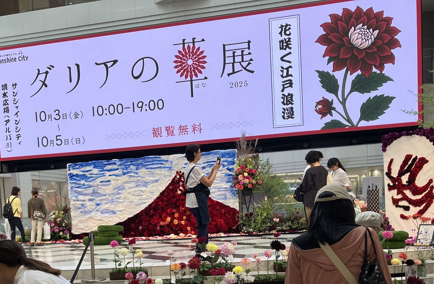 2025年のダリアの華展。赤いダリアで富士山を描いた大型装飾と、花咲く江戸浪漫と書かれた看板