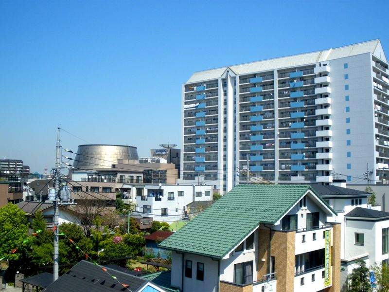 西新井の街並みを高い位置から見た写真。手前に住宅と集合住宅が並び、左奥にギャラクシティの銀色のドームが顔を出している
