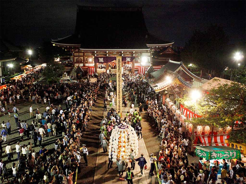 夜の池上本門寺の大堂前に万灯と参詣者が集まる様子