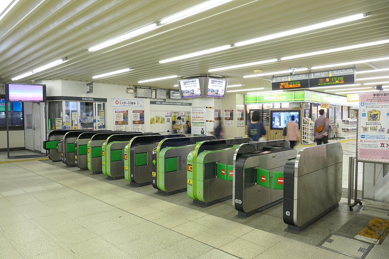 JR小岩駅の中央口改札。緑色の自動改札機が9通路並び、右手にコンビニと発車標が見える