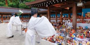 明治神宮本殿前の回廊に並べられた人形と神職