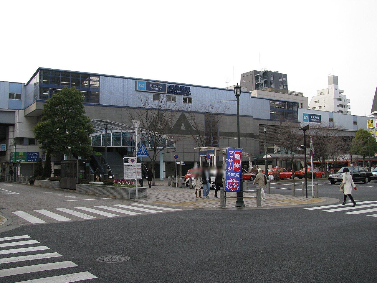 東京メトロ東西線・西葛西駅の駅舎と駅前広場。手前に横断歩道、右手にタクシーとバスの乗り場が並ぶ