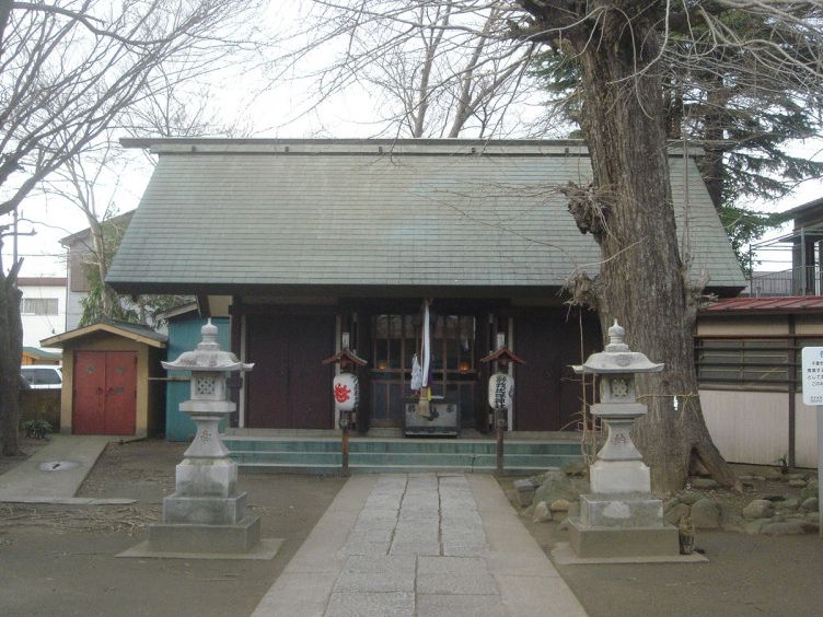 蘇我比咩神社の本殿。石畳の参道の先に社殿が建ち、両脇に石灯籠と大きな木が立っている