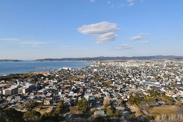 館山城から見下ろした館山市街と館山湾。海沿いに防波堤が伸び、遠くに房総の山並みが見える