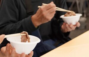 東京食肉市場まつりの無料試食で、しゃぶしゃぶを食べる来場者