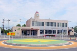 JR外房線八積駅の駅舎とロータリー。時計塔のある2階建ての建物に長生村コミュニティセンターが入っている