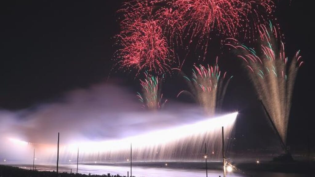 相模川の河川敷で横一線に流れ落ちるナイアガラの仕掛け花火と打ち上げ花火