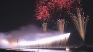 相模川の河川敷で横一線に流れ落ちるナイアガラの仕掛け花火と打ち上げ花火