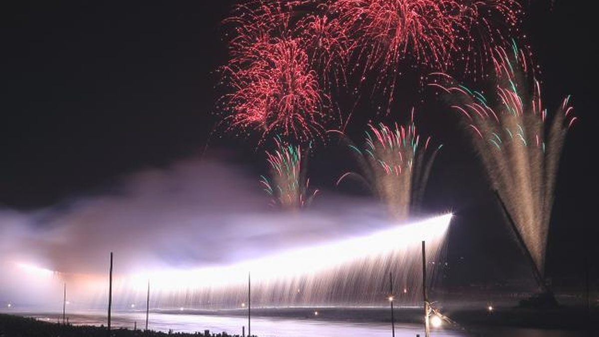 相模川の河川敷で横一線に流れ落ちるナイアガラの仕掛け花火と打ち上げ花火