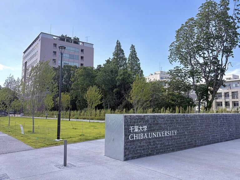 千葉大学西千葉キャンパスの入口の銘板と芝生、奥の校舎
