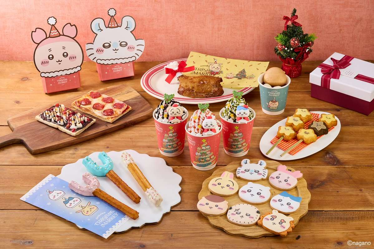 ちいかわクリスマスマーケットのフード紹介画像。木のテーブルに、ちいかわたちの顔のアイシングクッキー、マスコットとホイップがのったツリー柄のカップ3つ、星形の焼き菓子の串、ピンク・水色・白のチュロス、ピザ風のトースト2種、骨付きのチキン、丸いパンの入ったカップが並んでいる