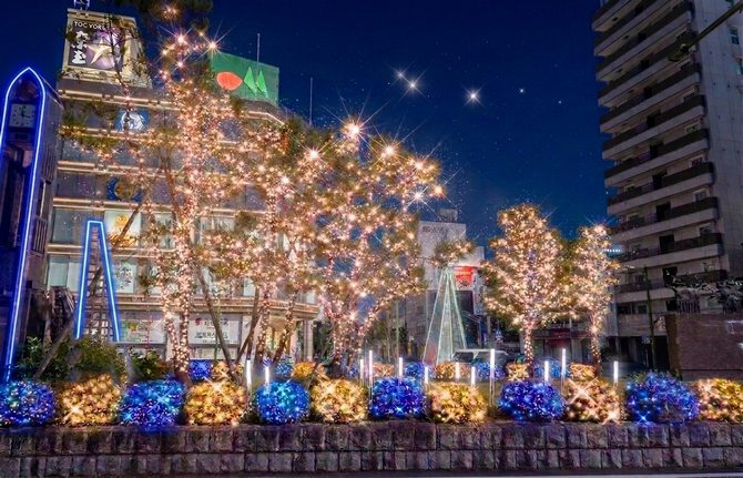 岩槻駅東口の駅前広場で、植え込みが青と金色の電飾で覆われ、木々が金色に光る完成イメージ
