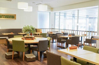 シナグロそごう大宮店の店内。窓際のテーブル席と丸テーブル。出典:薬糧開発株式会社