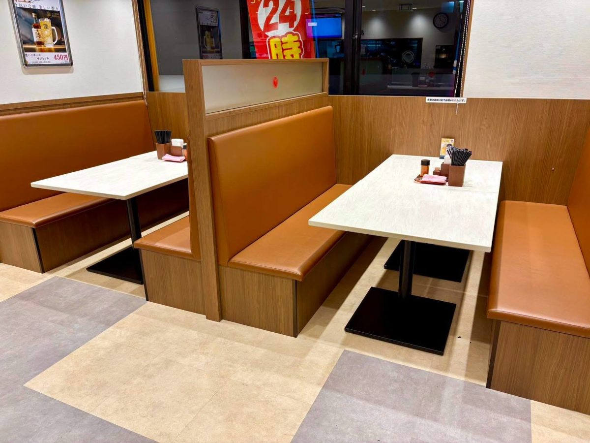 茶色のソファと白いテーブルのボックス席が仕切り越しに並ぶ店内