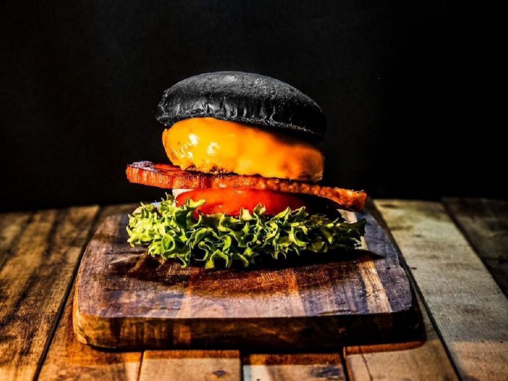 黒いバンズにベーコン、レタス、トマト、チーズを挟んだBLACK BURGERのBLTバーガー