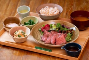 木のお盆に、炙った牛肉のたたきとサラダの皿、ごはん、味噌汁、小鉢が並ぶ御膳