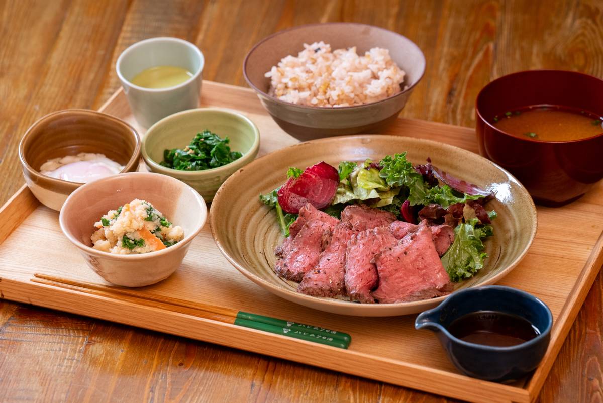 木のお盆に、炙った牛肉のたたきとサラダの皿、ごはん、味噌汁、小鉢が並ぶ御膳