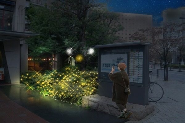 低い植栽に敷き詰めた光と、樹木の星形の光の前で写真を撮る人