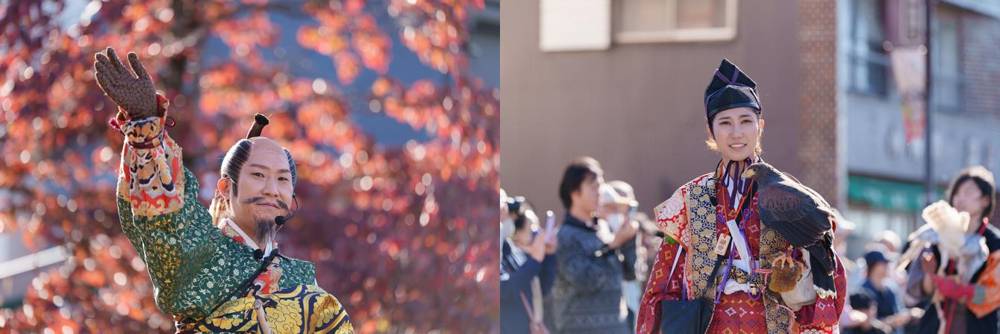 紅葉を背に手を挙げる将軍役の人と、鷹を腕にのせて沿道を歩く女性の鷹匠