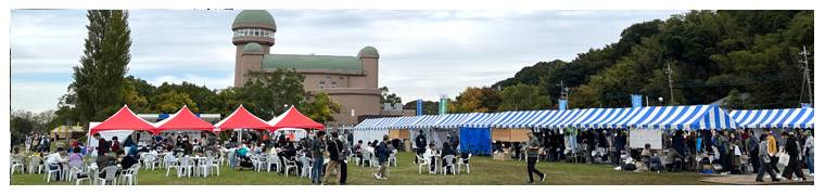 2025年のジャパンバードフェスティバル。手賀沼親水広場に並ぶ赤と青白のテント、JAPAN BIRD FESTIVALのバナー、巡回バス